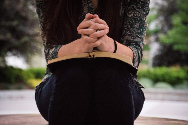 Woman with Bible praying